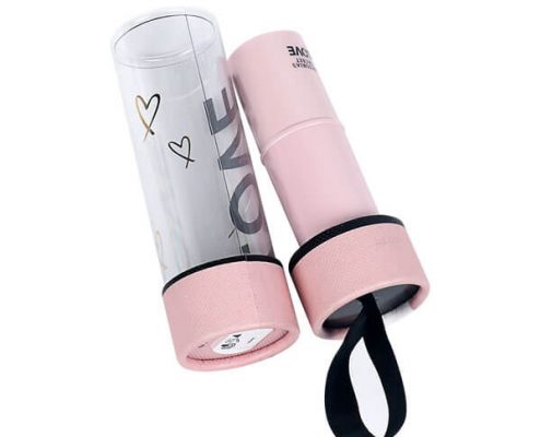 Plastic and cardboard lip balm containers with a stylish pink design.