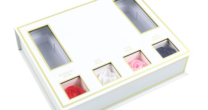 Red rigid box packaging for perfume sampler set, featuring a magnetic closure and custom inserts for organizing sample bottles.