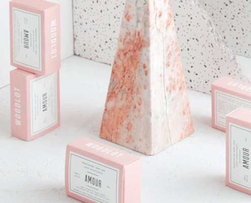 Elegant pink soap packaging boxes with a minimalistic design, showcased next to a marble-textured display piece.