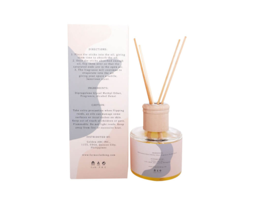 Reed diffuser packaging box with orange and botanical design elements.