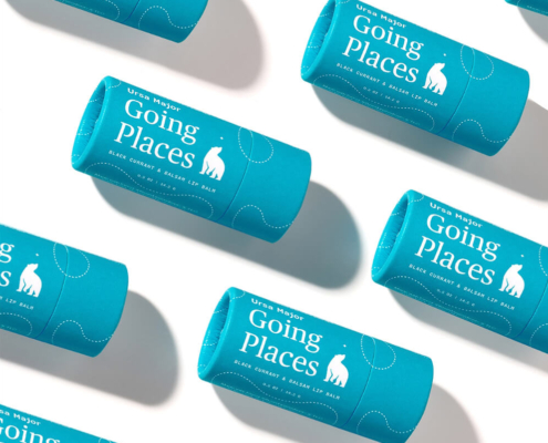 Multiple eco-friendly lip balm tubes arranged diagonally, emphasizing sustainable packaging in bright blue paperboard.