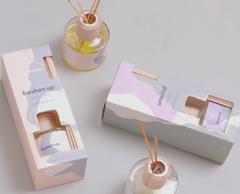 Stylish reed diffuser packaging displayed with glass diffuser bottle and reeds.