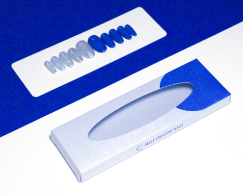 Oval window press on nail packaging box showing a blue and silver nail set.