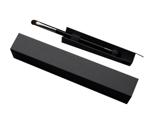 Image of a single black makeup brush box with an open lid revealing a makeup brush inside.