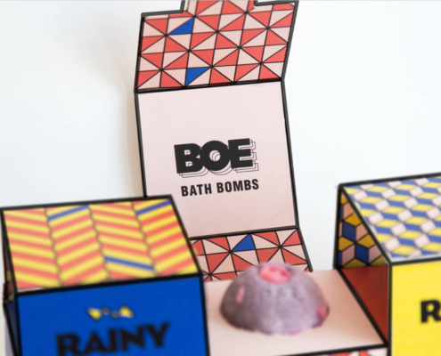 Close-up of the BOE Bath Bombs logo printed on the inner side of colorful custom bath bomb packaging.