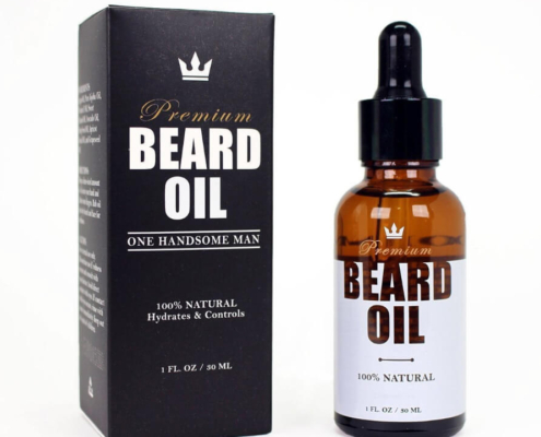 Elegant black and white premium beard oil box labeled "One Handsome Man" with a matching amber dropper bottle for 100% natural ingredients.