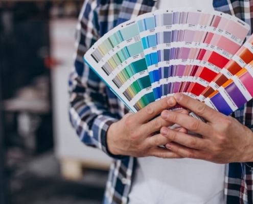 Person holding Pantone color swatch fan used for accurate color matching in printing