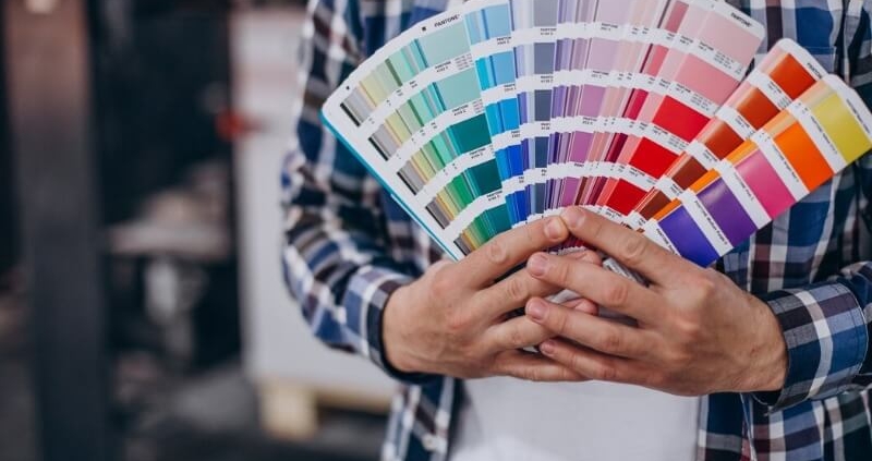 Person holding Pantone color swatch fan used for accurate color matching in printing