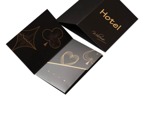 Luxury black custom card holder with gold suit designs – A sleek black key card holder with intricate gold-foil suit patterns, perfect for hotels aiming to add elegance to their guest welcome experience.