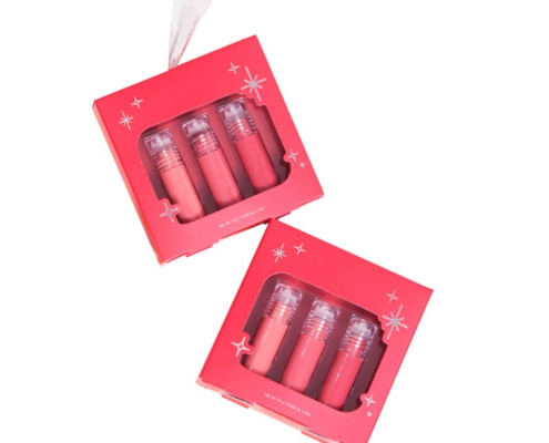 Two red lip gloss gift boxes, each holding three glosses, with decorative star details on the packaging