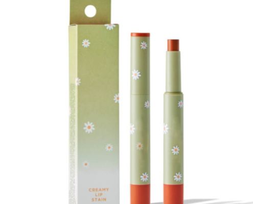 Green lipstick box packaging with floral design and matching lipstick tube displayed upright, featuring a hang hole for easy retail display.