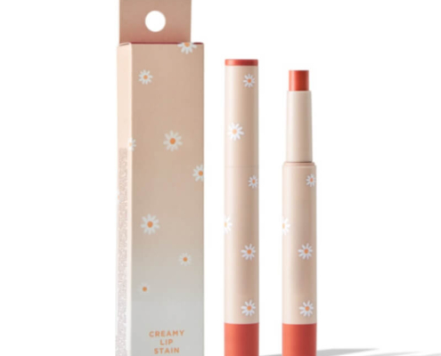 Cream-colored lipstick box packaging with daisy motifs, featuring a matching lipstick tube, combining elegance and functionality.