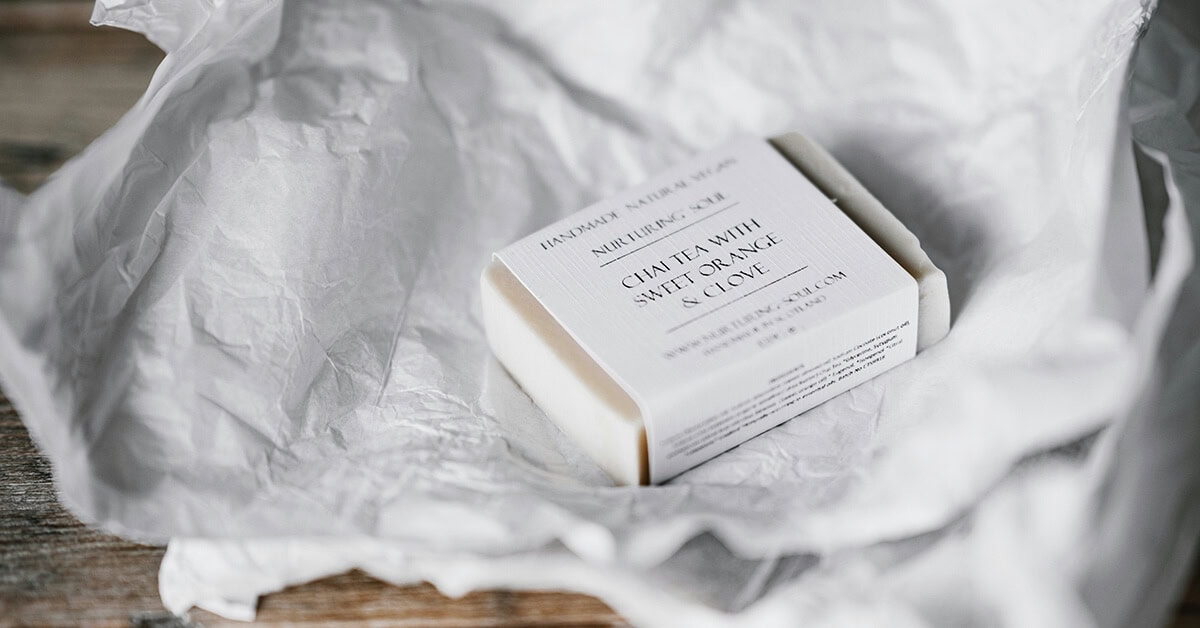 a soap bar packed in a white textured paper sleeve