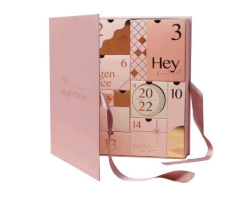 Pink advent calendar box with magnetic closure and ribbon handle for luxury gifting.