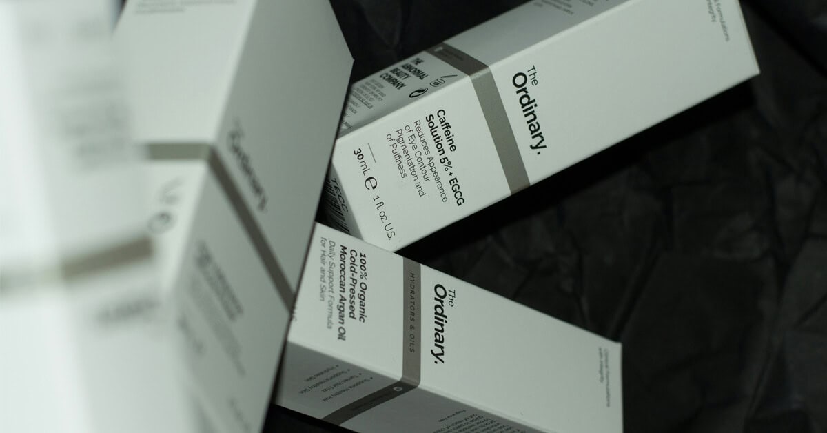 Stacked minimalist white packaging boxes for skincare brand The Ordinary.