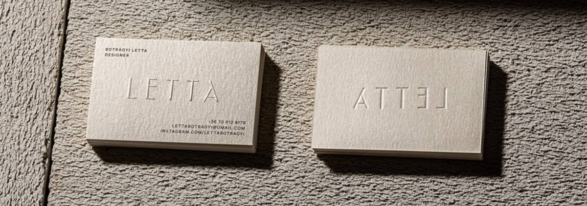 Embossed business cards with raised lettering, showcasing the word "LETTA" in a minimalist design.