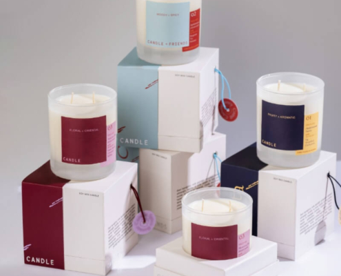 A group of luxury candle boxes in different colors, stacked with candles, displaying a variety of scents and eco-friendly packaging.