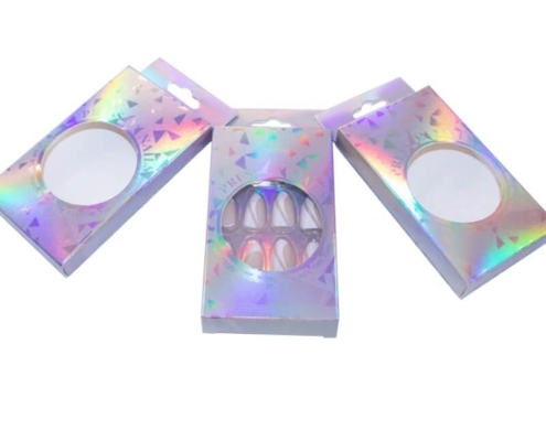 Set of retail-ready press on nails packaging in holographic folding carton boxes with round windows for eye-catching shelf presentation.