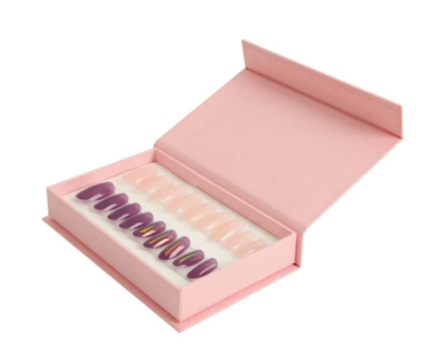 Soft pink magnetic nail packaging box holding multicolored press-on nails in foam insert.