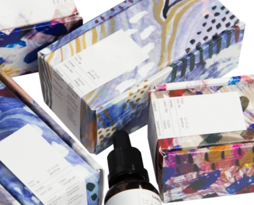 Close-up of printed serum boxes and a dropper bottle – premium serum boxes in coated paper and kraft material.